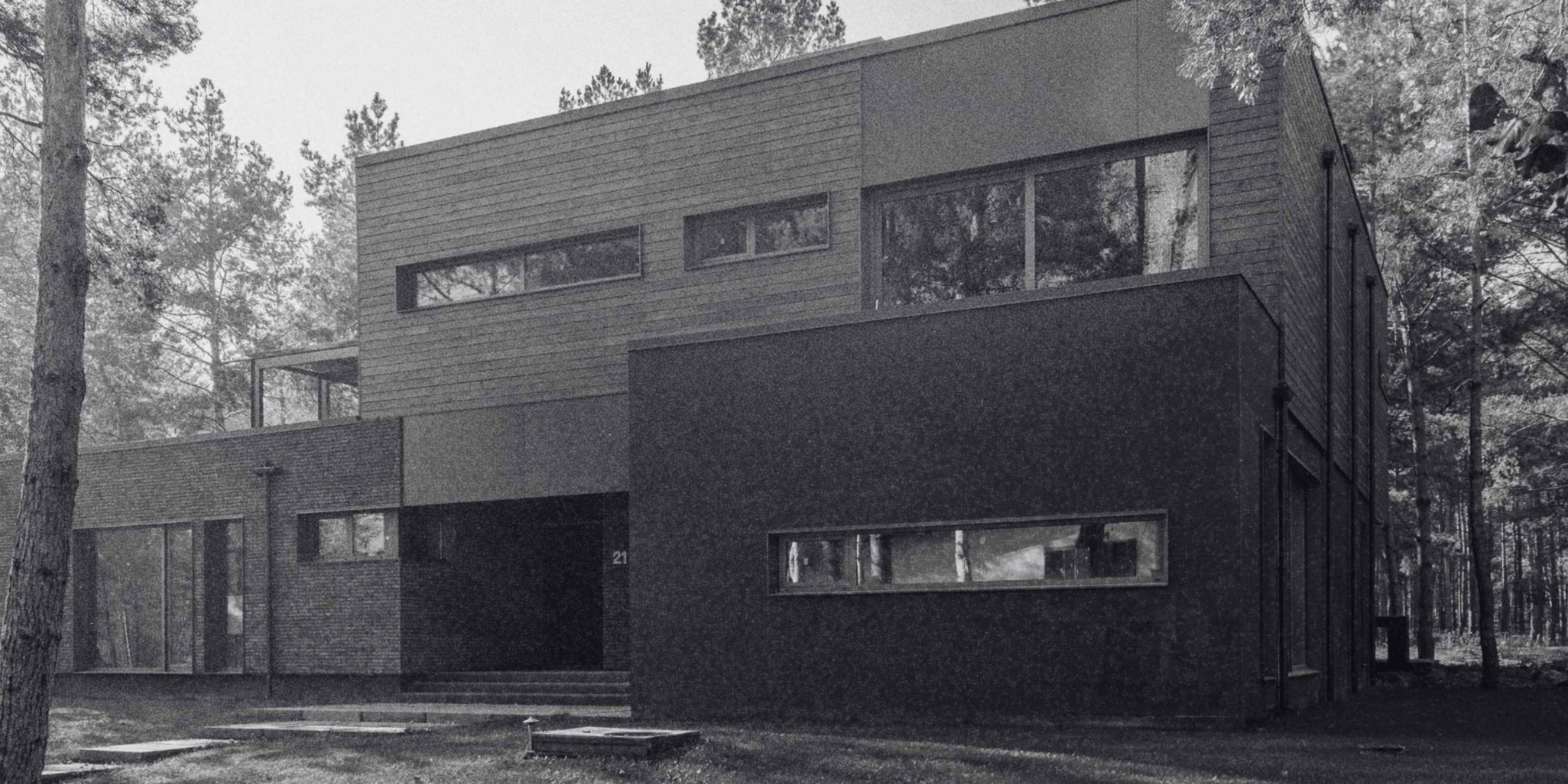 Contemporary custom home exterior featuring dark finishes, clean lines, expansive windows, and modern architecture.
