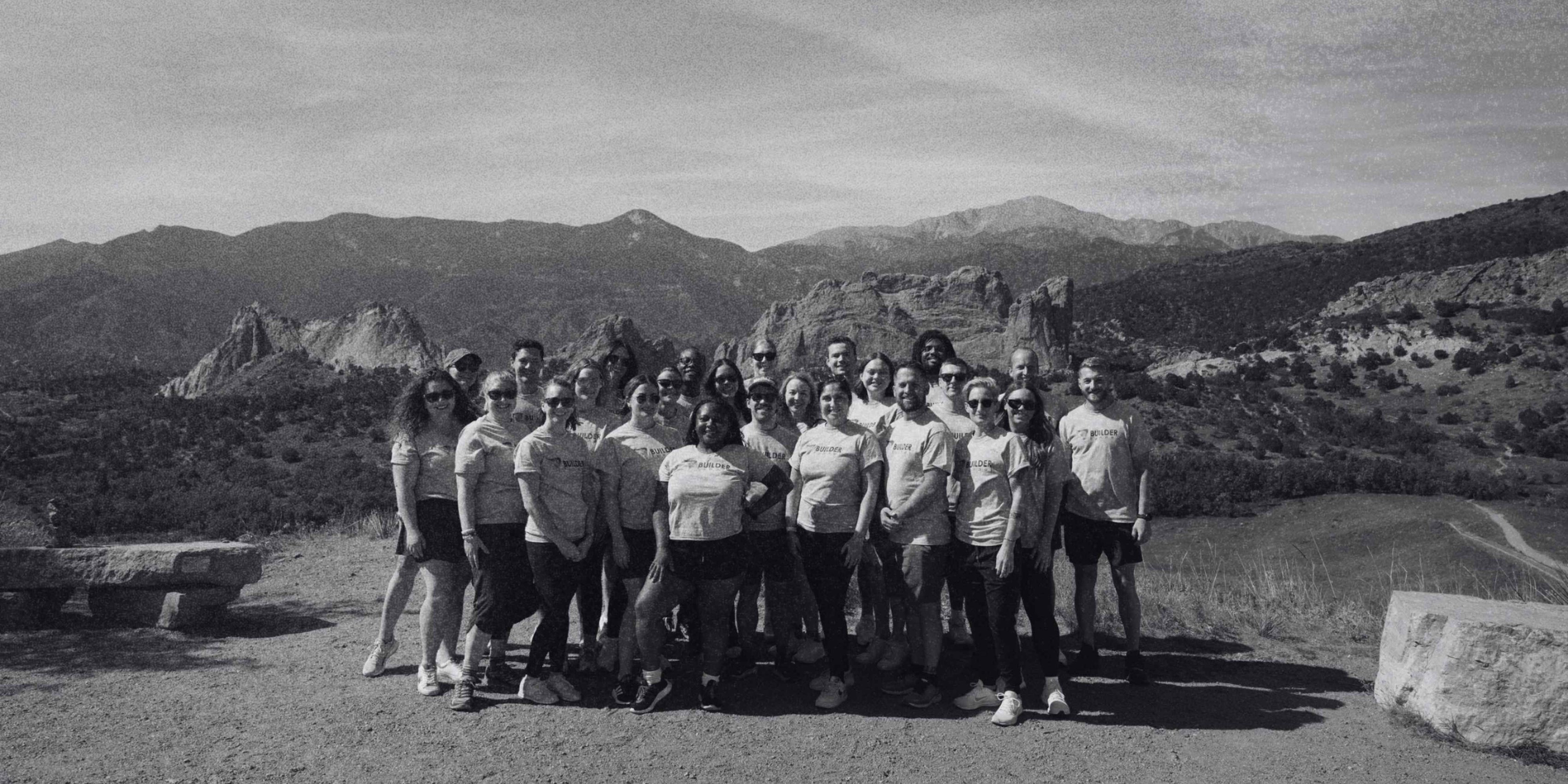 Builder Funnel team gathered outdoors with mountain views and dramatic rock formations in the background.