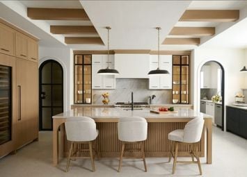 Kitchen featuring a wood island, upholstered seating, glass-front cabinets, arched openings, and ceiling beams.